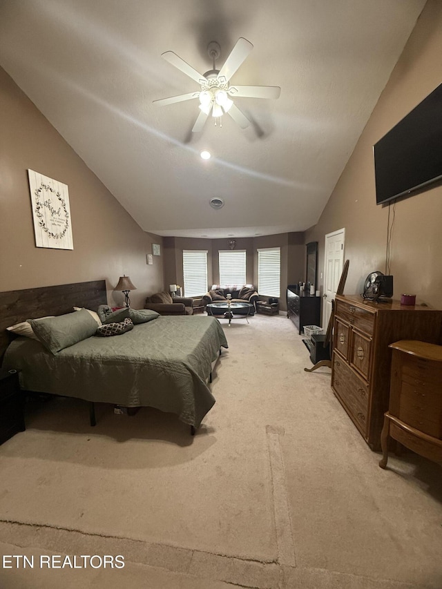 bedroom with vaulted ceiling, a ceiling fan, and carpet flooring