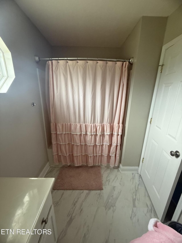 bathroom featuring a shower with curtain and marble finish floor