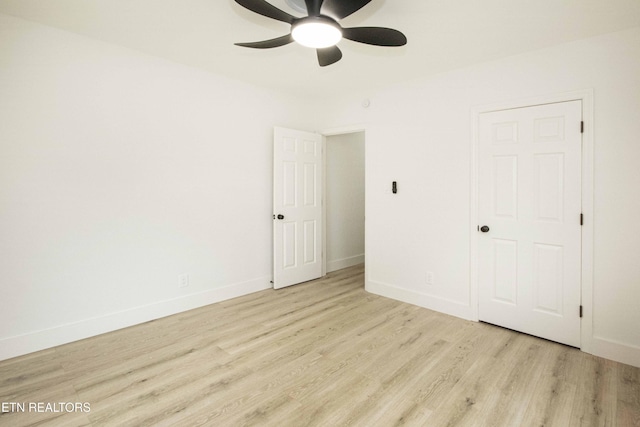 unfurnished bedroom with light wood-type flooring, a ceiling fan, and baseboards