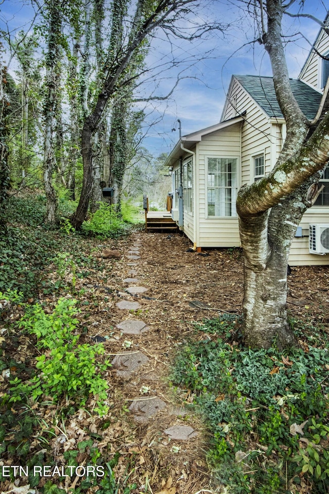 view of side of property with ac unit and a wooden deck