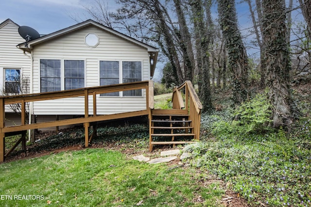 rear view of house featuring stairs and a wooden deck