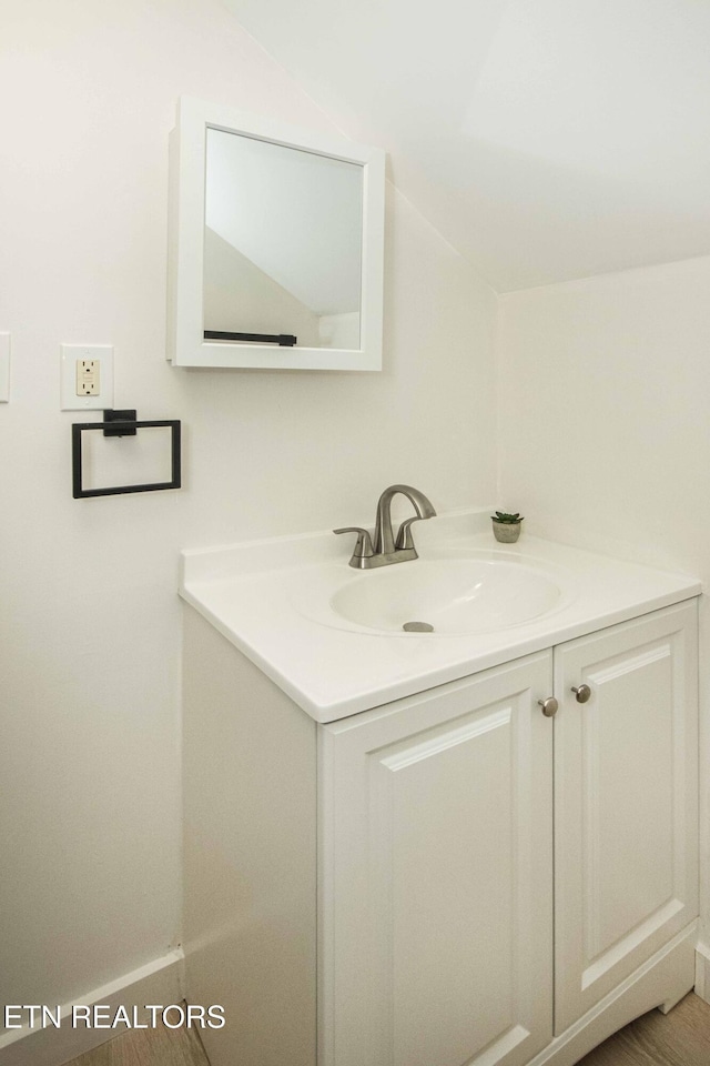 bathroom with vanity and lofted ceiling