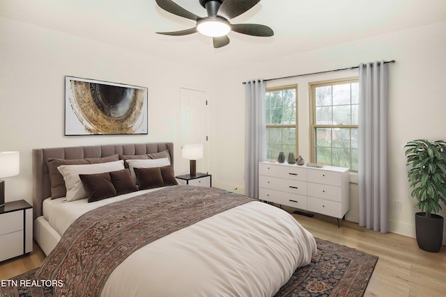 bedroom with a ceiling fan, baseboards, and light wood-style floors