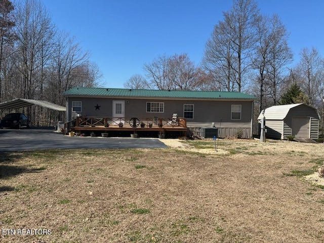 145 Liles Ln, Rocky Top, TN 37769 - rear view of property featuring metal roof, a storage shed, a detached carport, and an outbuilding