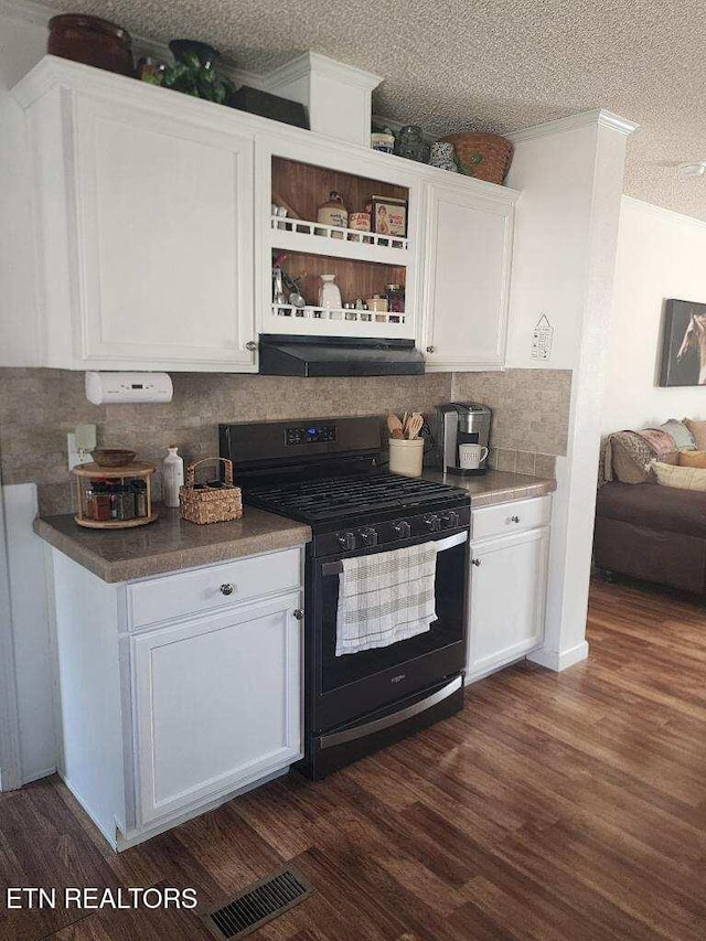 145 Liles Ln, Rocky Top, TN 37769 - kitchen with dark wood-type flooring, under cabinet range hood, black gas range, and white cabinets