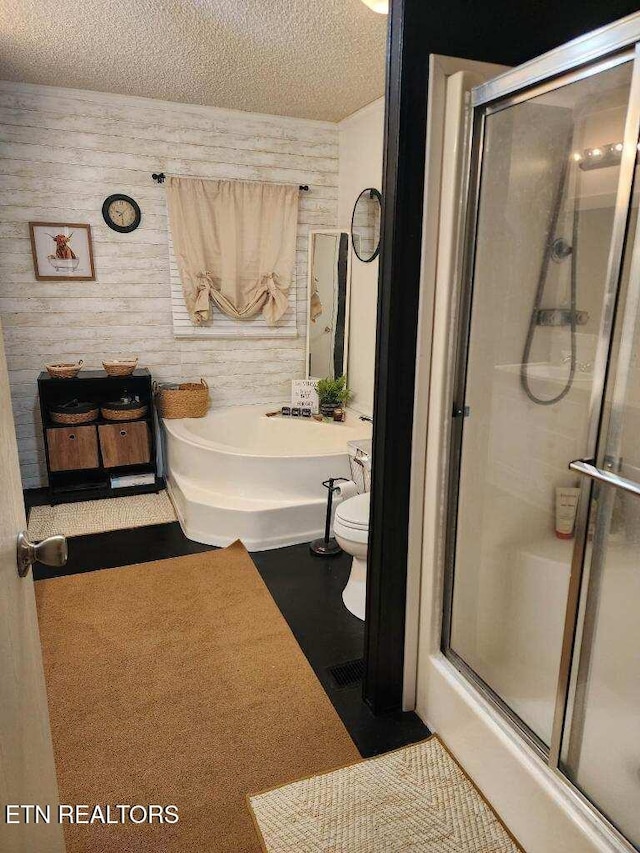145 Liles Ln, Rocky Top, TN 37769 - bathroom featuring a textured ceiling, a washtub, toilet, wood walls, and a stall shower