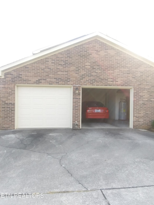 garage featuring water heater and concrete driveway