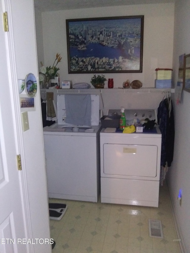 laundry area with laundry area, light tile patterned floors, and washer and clothes dryer