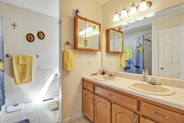 full bath with tile patterned flooring, double vanity, a shower with curtain, and a sink