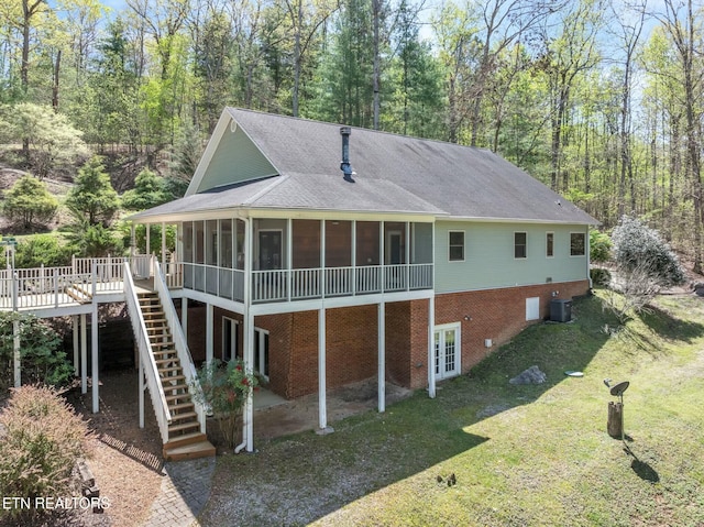 rear view of house featuring a sunroom, a lawn, stairway, cooling unit, and a wooden deck