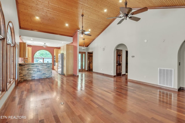 unfurnished living room with ceiling fan, wooden ceiling, and arched walkways