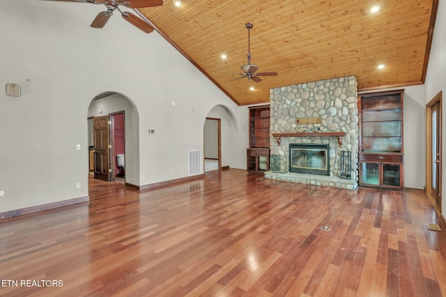 unfurnished living room with high vaulted ceiling, ceiling fan, visible vents, wood ceiling, and built in shelves