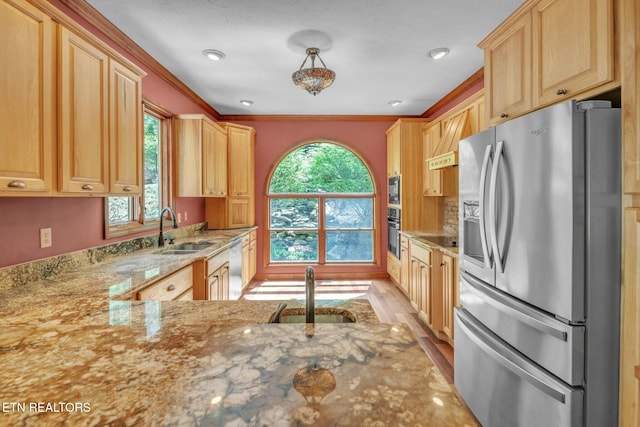 kitchen with light brown cabinetry, a sink, black appliances, and light stone counters