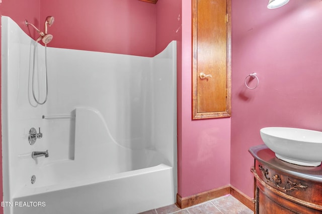bathroom with vanity, baseboards, tile patterned flooring, and shower / washtub combination