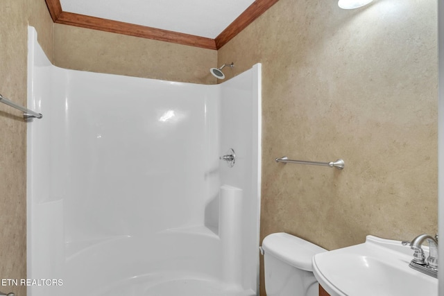 full bath with a sink, walk in shower, toilet, and crown molding