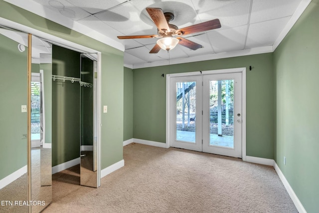 unfurnished bedroom with access to outside, ceiling fan, carpet, a closet, and baseboards