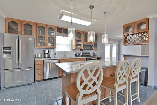 kitchen with glass insert cabinets, brown cabinets, and stainless steel appliances