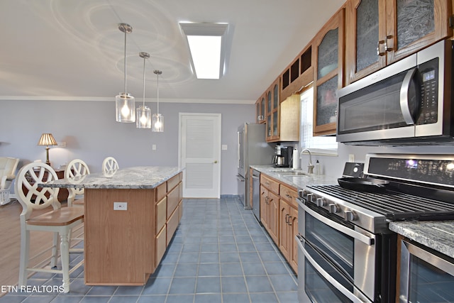 kitchen featuring crown molding, a kitchen bar, a center island, a sink, and stainless steel appliances