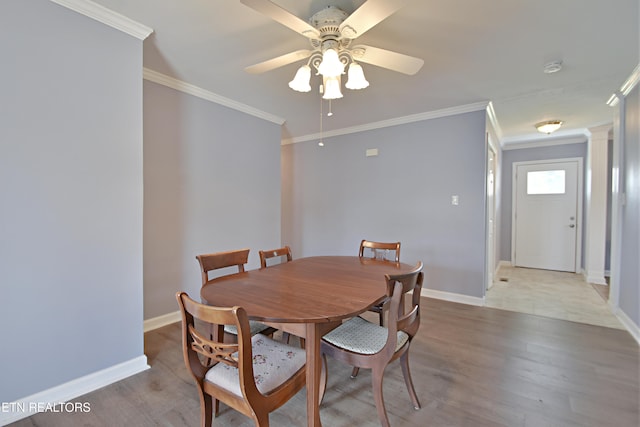 dining space featuring crown molding, baseboards, and a ceiling fan
