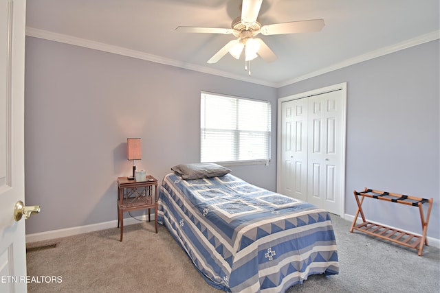 carpeted bedroom featuring crown molding, baseboards, ceiling fan, and a closet