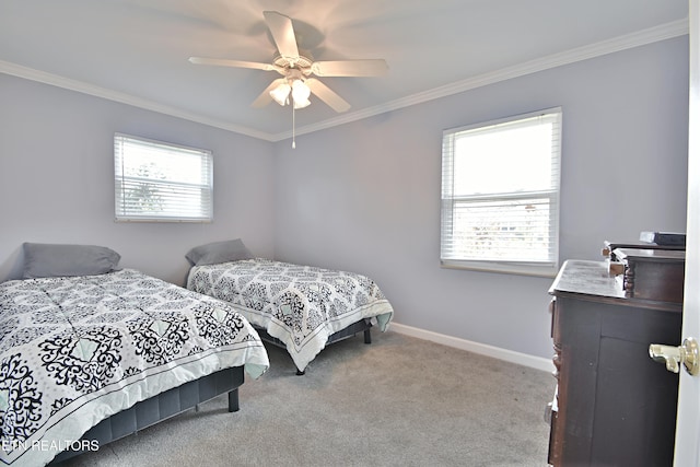 carpeted bedroom with crown molding, baseboards, and ceiling fan