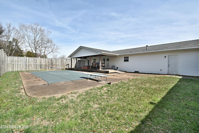 view of swimming pool with a diving board, a fenced backyard, a patio area, and a yard