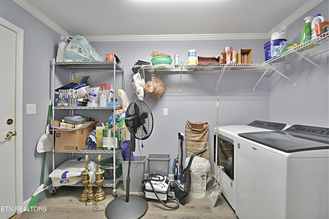 clothes washing area with wood finished floors, laundry area, washing machine and dryer, and ornamental molding