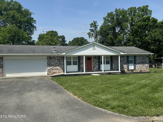 single story home featuring a porch, driveway, a front yard, a garage, and brick siding