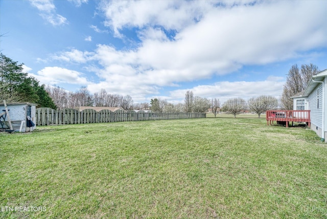 view of yard featuring a deck and fence