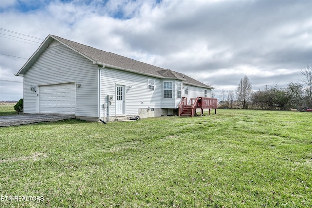 exterior space with aphalt driveway, a wooden deck, roof with shingles, a yard, and an attached garage