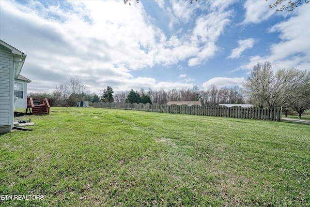 view of yard featuring a wooden deck and fence