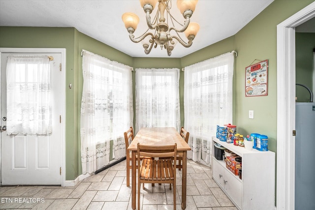 dining space featuring a healthy amount of sunlight, a chandelier, and water heater