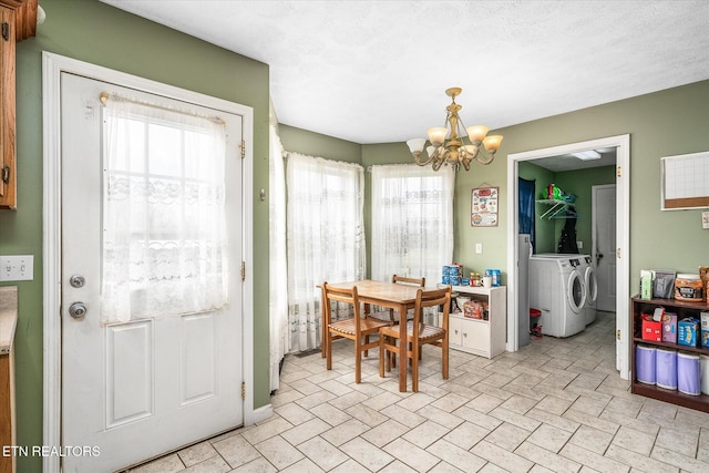 dining area with washer and dryer, a notable chandelier, and a textured ceiling
