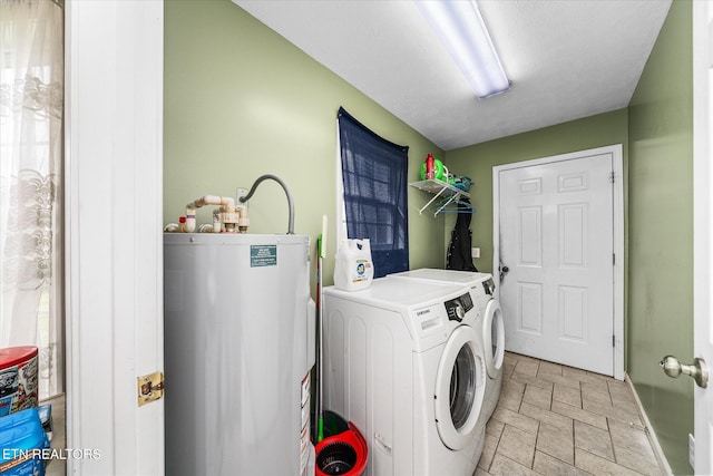 laundry area with stone finish floor, water heater, laundry area, independent washer and dryer, and a textured ceiling