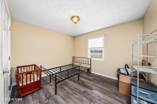 bedroom featuring baseboards and wood finished floors