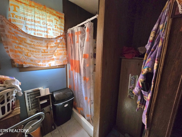 bathroom with tile patterned flooring and a shower stall