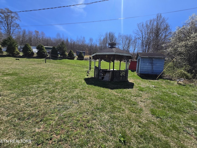 view of yard featuring a gazebo, a storage shed, and an outbuilding