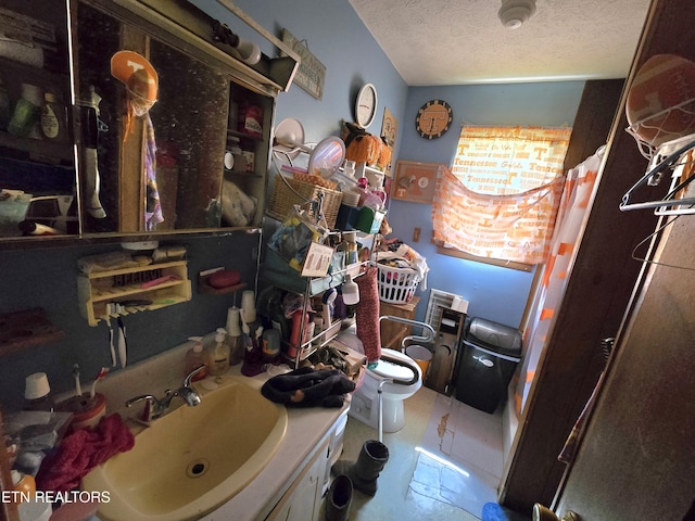 bathroom featuring a shower with shower curtain, a textured ceiling, toilet, and vanity