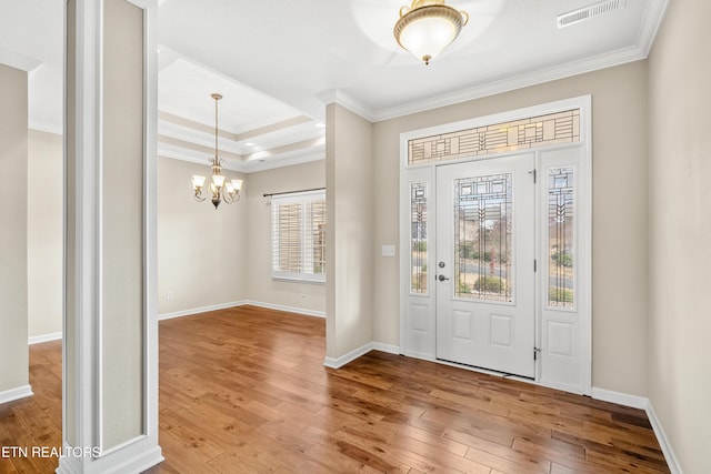entryway featuring a notable chandelier, visible vents, crown molding, and wood-type flooring