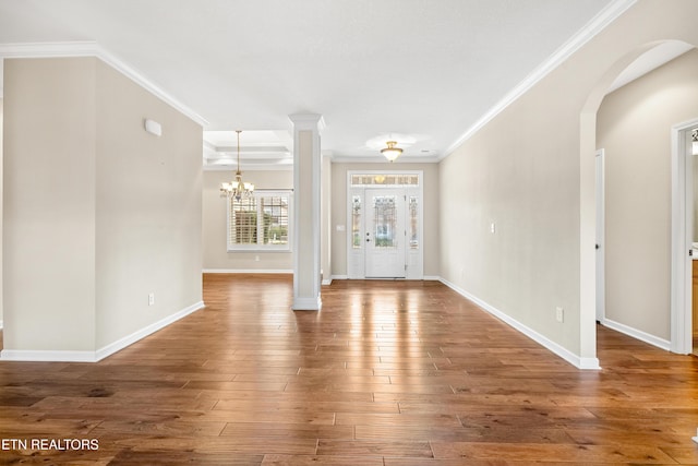 entrance foyer featuring baseboards, a notable chandelier, crown molding, and wood finished floors
