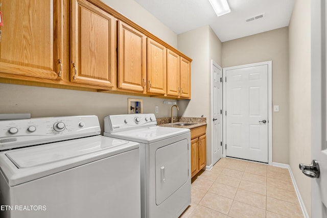 laundry area featuring light tile patterned flooring, visible vents, a sink, washer and dryer, and cabinet space