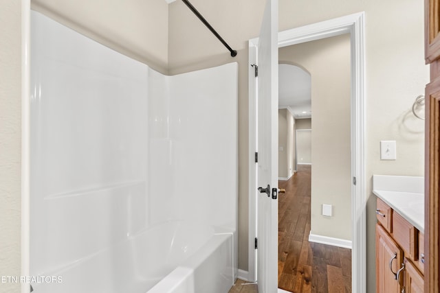 full bathroom featuring baseboards,  shower combination, wood finished floors, and vanity