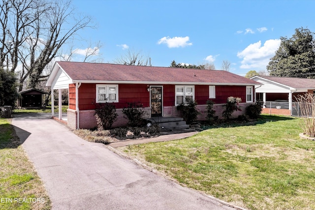 single story home featuring brick siding, a shingled roof, a front lawn, and fence