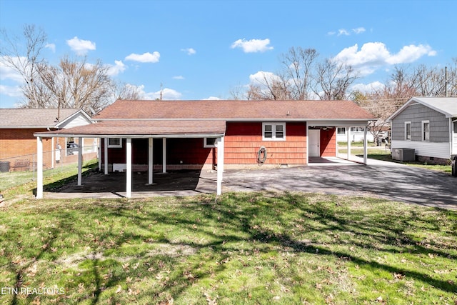 exterior space featuring a carport, central AC, a yard, and driveway