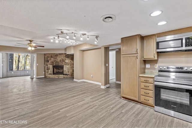 221 Woodland Rd Unit 315, Gatlinburg, TN 37738 - kitchen with a fireplace, light wood-type flooring, a ceiling fan, light countertops, and stainless steel appliances