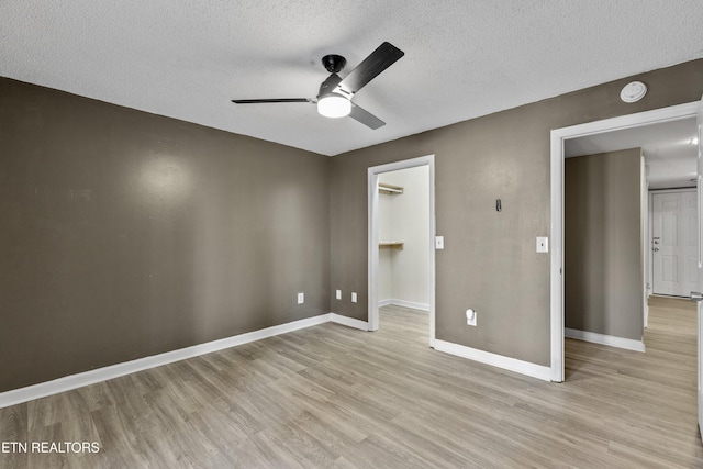 221 Woodland Rd Unit 315, Gatlinburg, TN 37738 - unfurnished bedroom featuring light wood-style flooring, a textured ceiling, baseboards, and a walk in closet