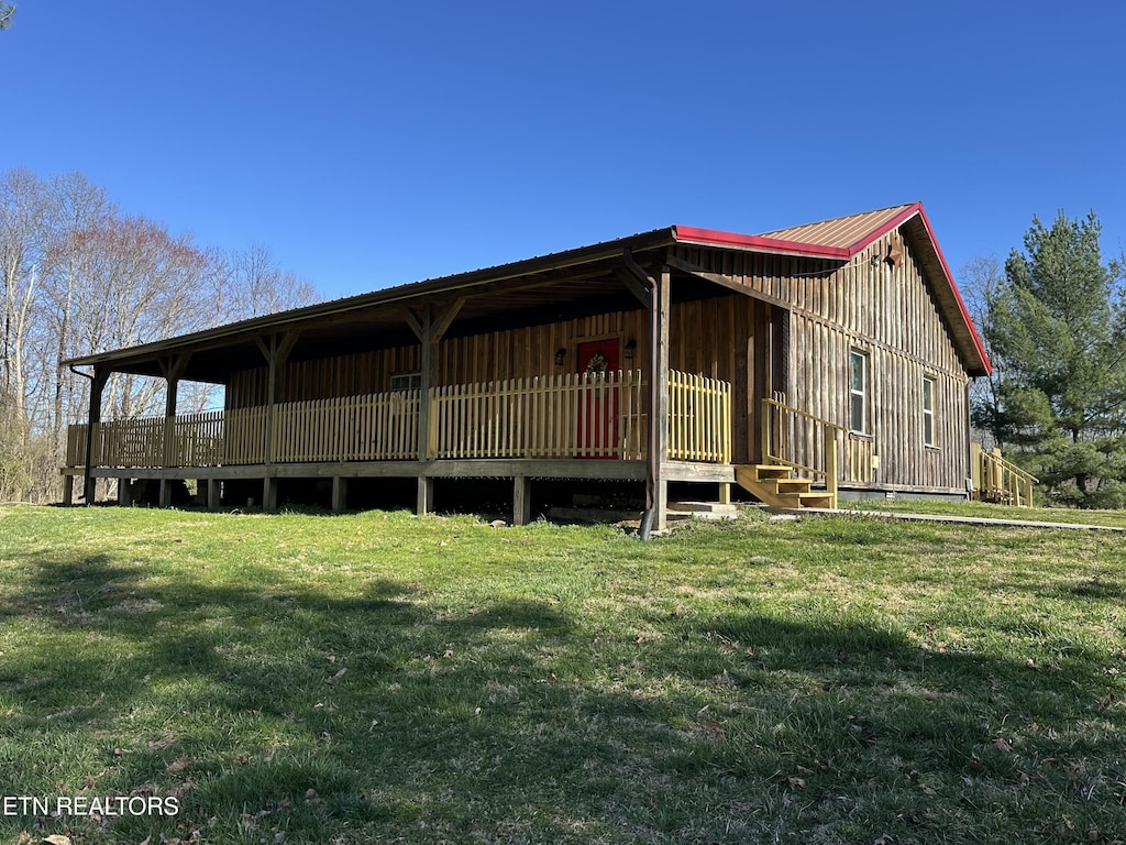 exterior space featuring metal roof and a front yard