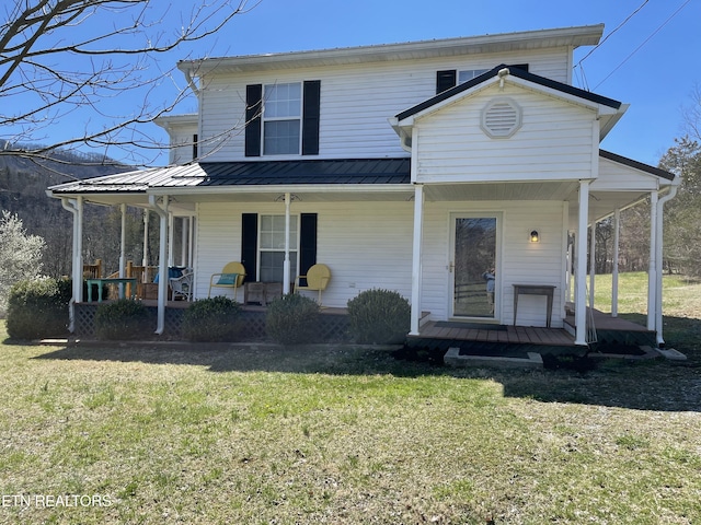 view of front of property featuring a front lawn, covered porch, and metal roof