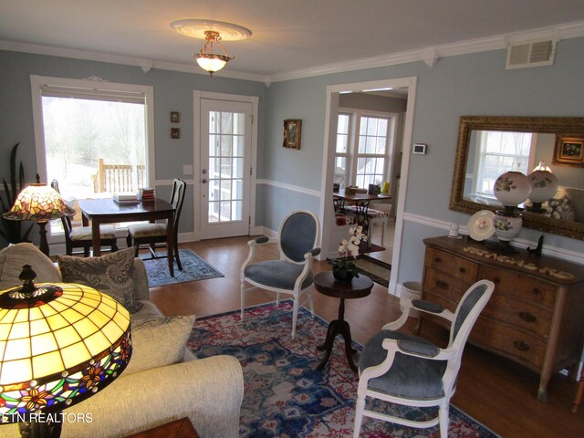 living room with visible vents, a healthy amount of sunlight, and ornamental molding