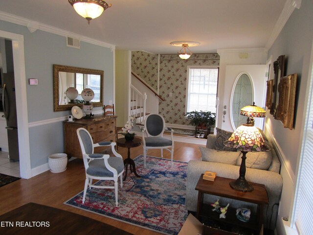 living room with stairway, crown molding, visible vents, and wood finished floors